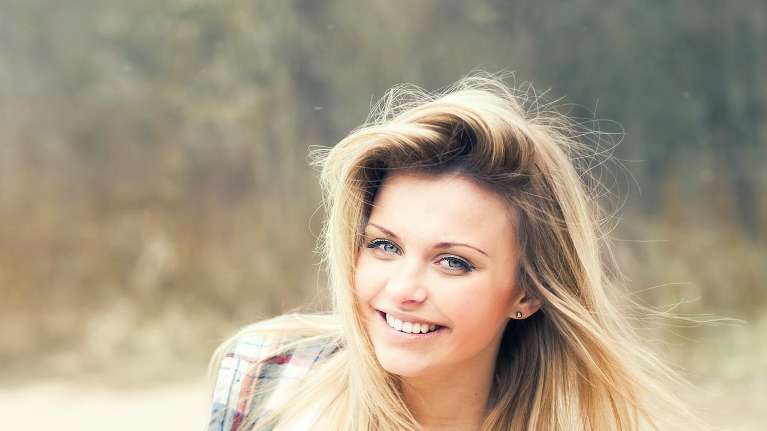 Blonde woman with green eyes smiling
