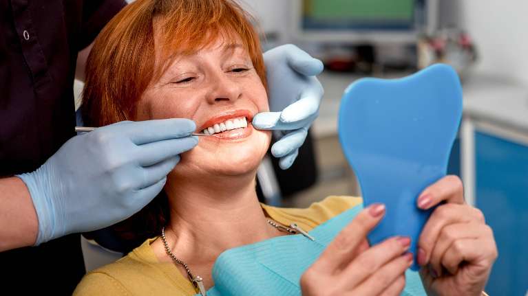 dental implants gretna | woman smiling at dentist