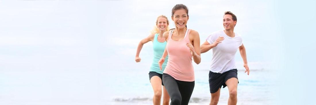 three adults running down beach | Dentist Gretna LA